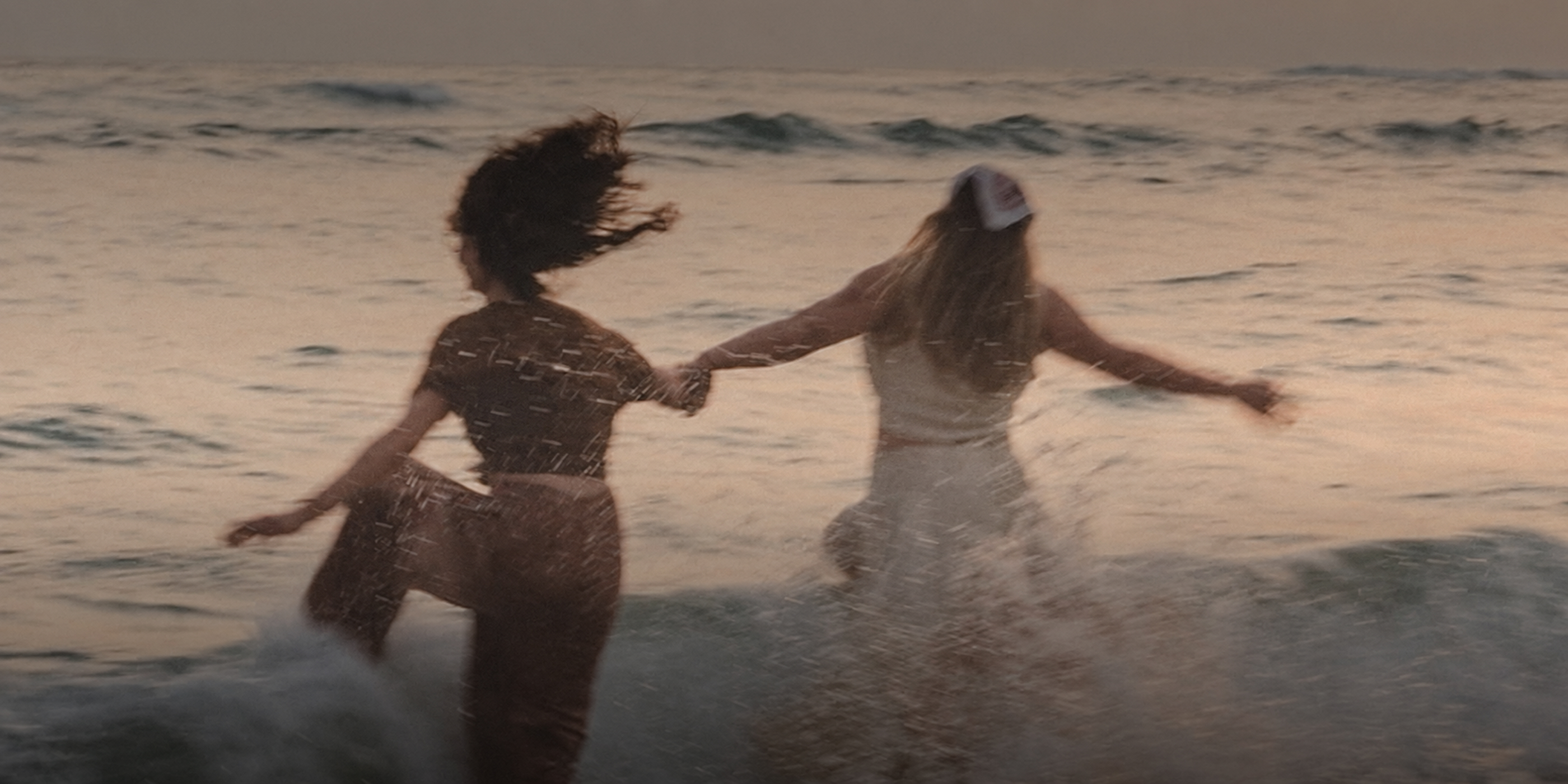 Two people enjoying the sea at sunset